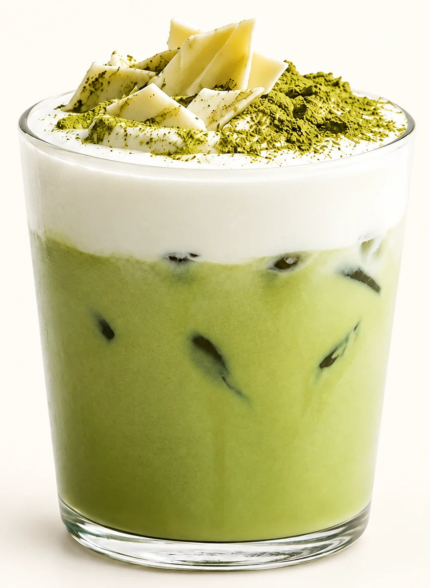 Creamy iced matcha latte topped with whipped cream, white chocolate curls and matcha powder