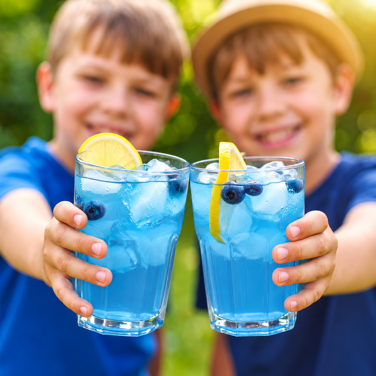 Two boys holding iced Very Berry Blue Drink refreshers outdoors